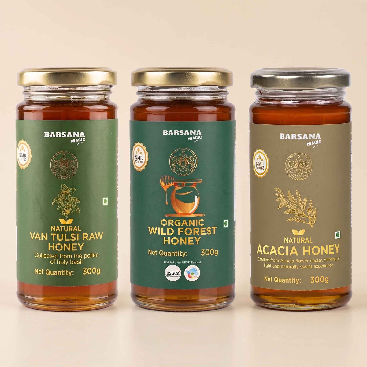 Barsana Magic and Three glass jars of Barsana brand honey arranged side by side on a light beige background. The left jar is labeled Natural Van Tulsi Raw Honey with a green label and gold lid.