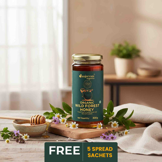 Barsana Magic and Jar of organic wild forest honey on a wooden table with flowers and a honey dipper.